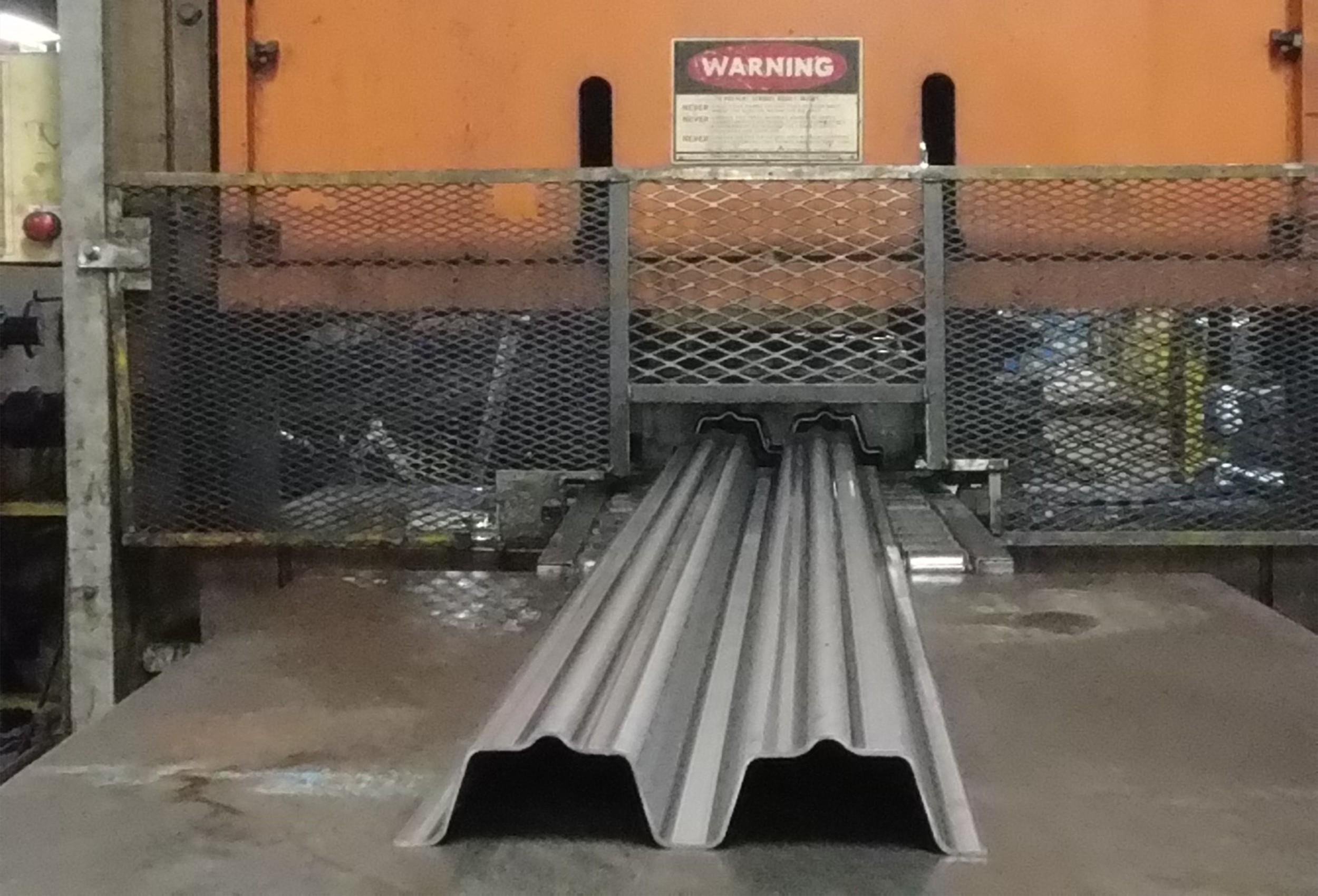 Finished roll-formed steel structural profiles exiting press line at Pennant's Ohio manufacturing facility.